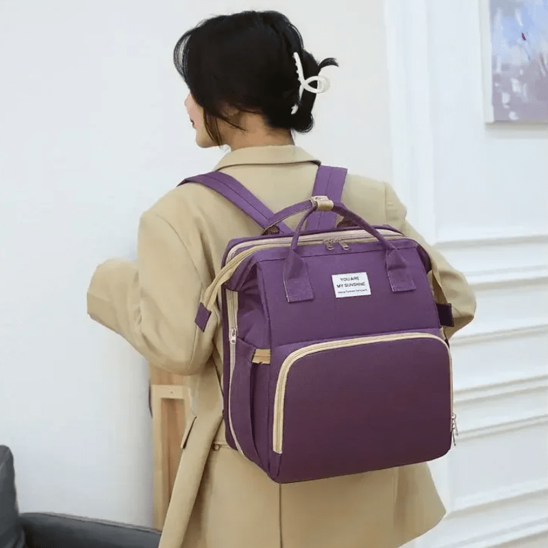 personne portant sac de voyage violet