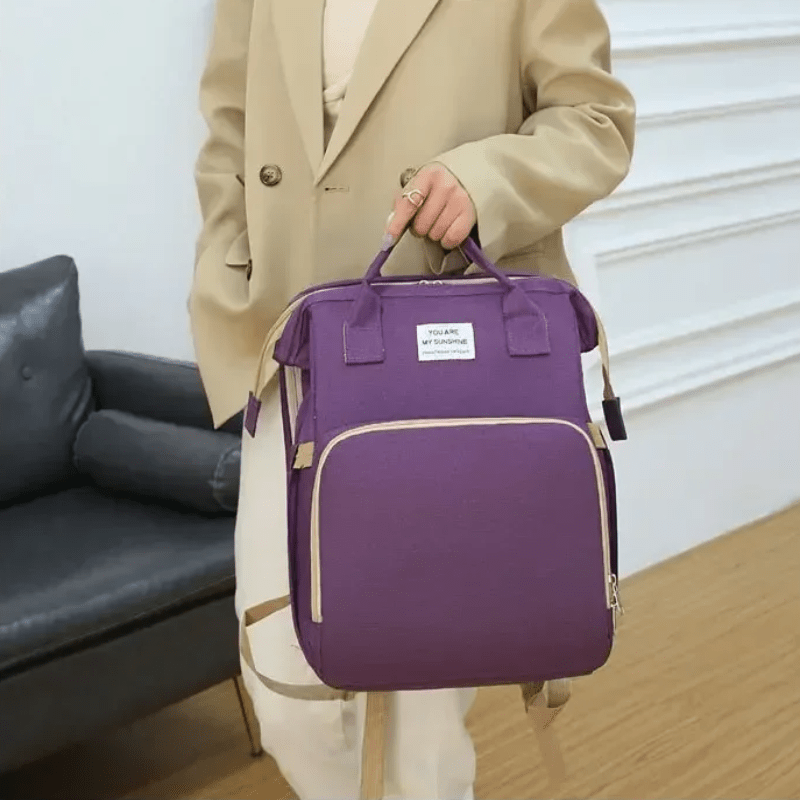 personne tenant sac de voyage violet